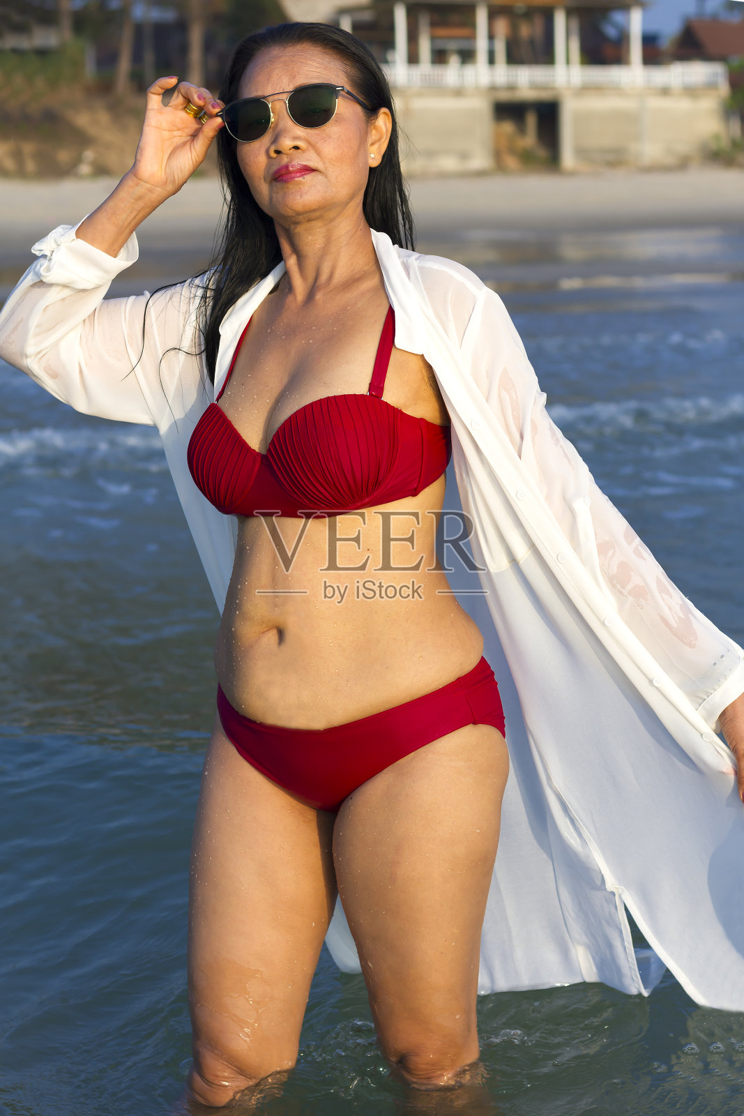 在沙滩上穿着红色比基尼的女人身体很漂亮照片摄影图片