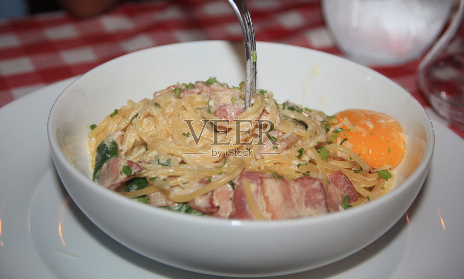 白碗焗意大利面配培根、鸡蛋及欧芹照片摄影图片