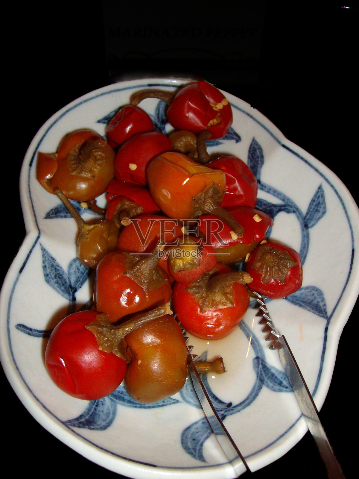 用白色的特制盘子盛上红腌辣椒。照片摄影图片