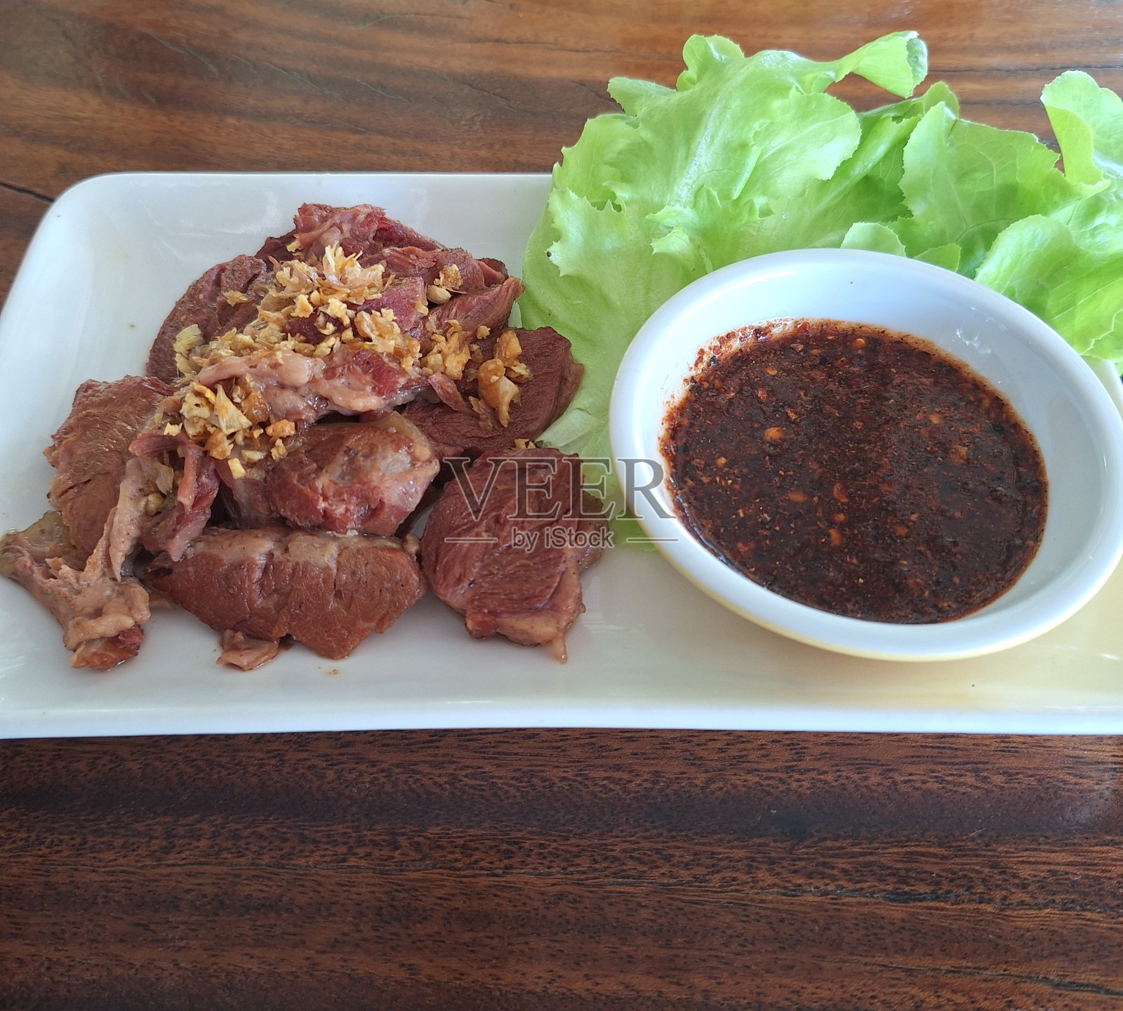 红烧肉配沙拉蔬菜和酱汁。照片摄影图片