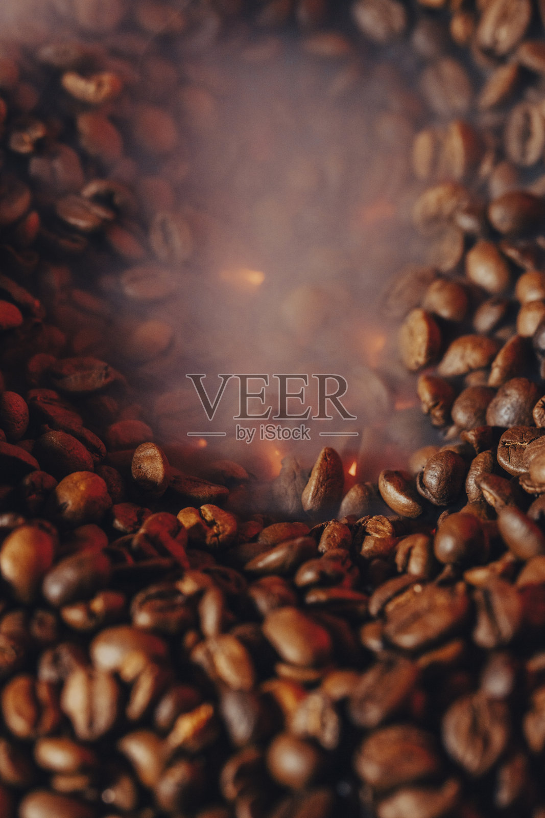 有烟和火背景的烘焙咖啡豆。关闭了,照片摄影图片