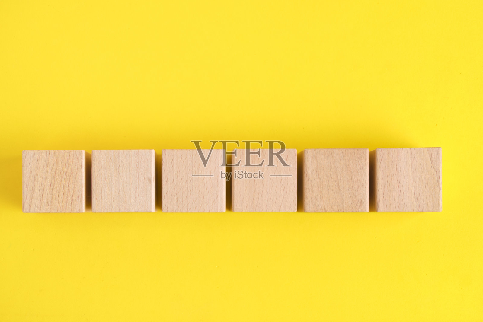 山毛榉木立方体黄色背景。照片摄影图片