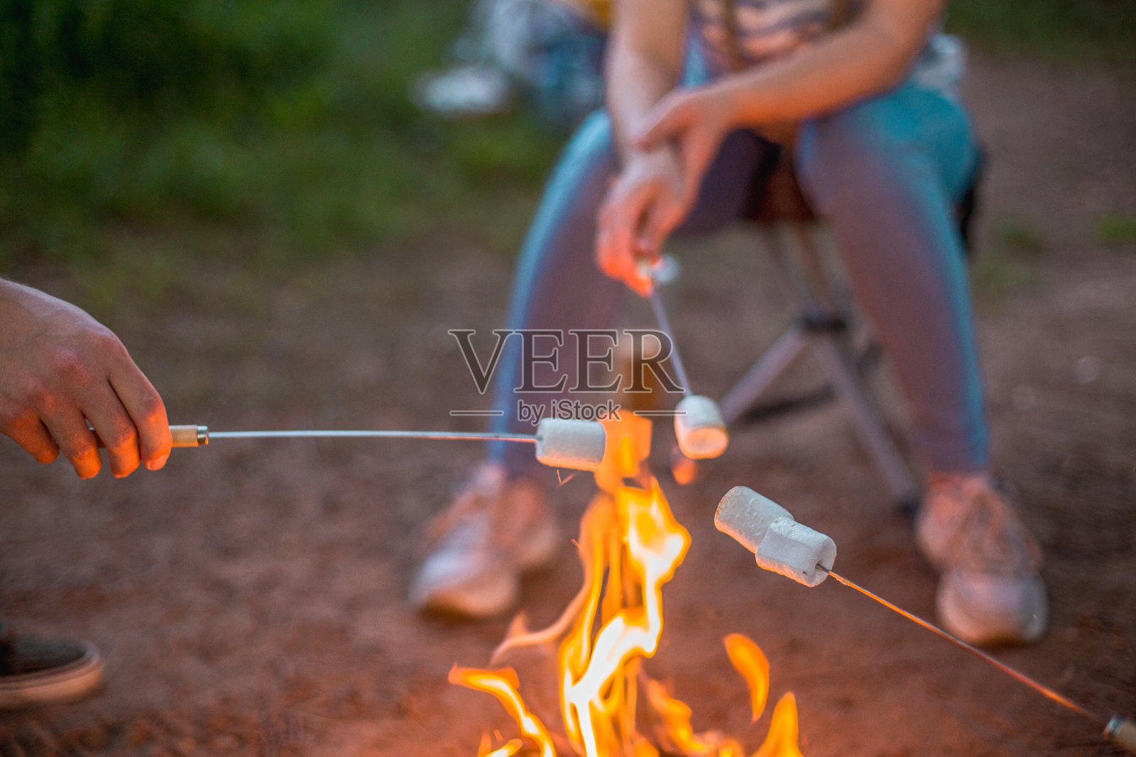 在篝火上烤棉花糖，朋友们在户外共度时光照片摄影图片