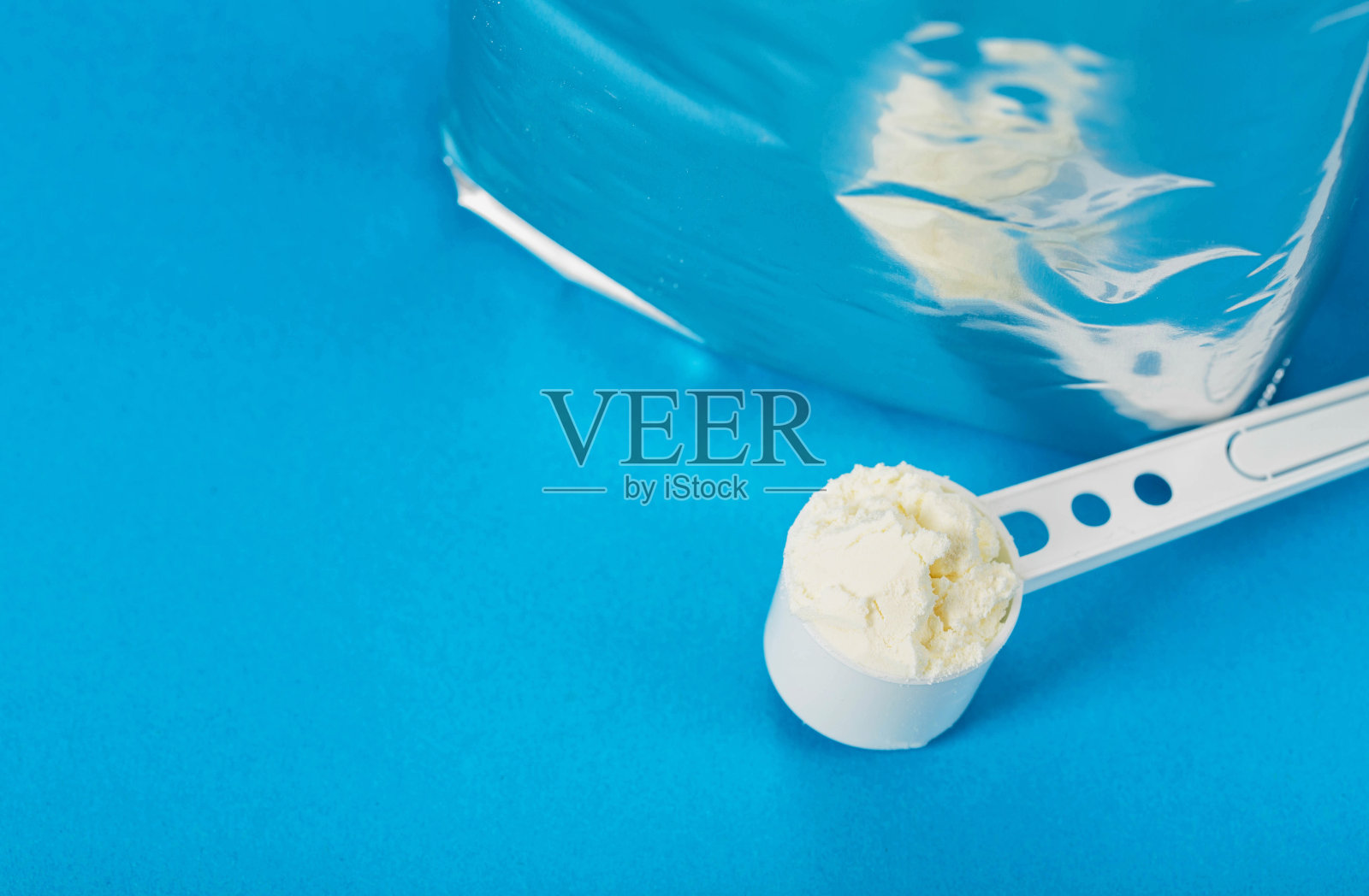 闪亮的包装与奶粉食品在蓝色的背景。婴儿配方奶粉。文本复制空间照片摄影图片