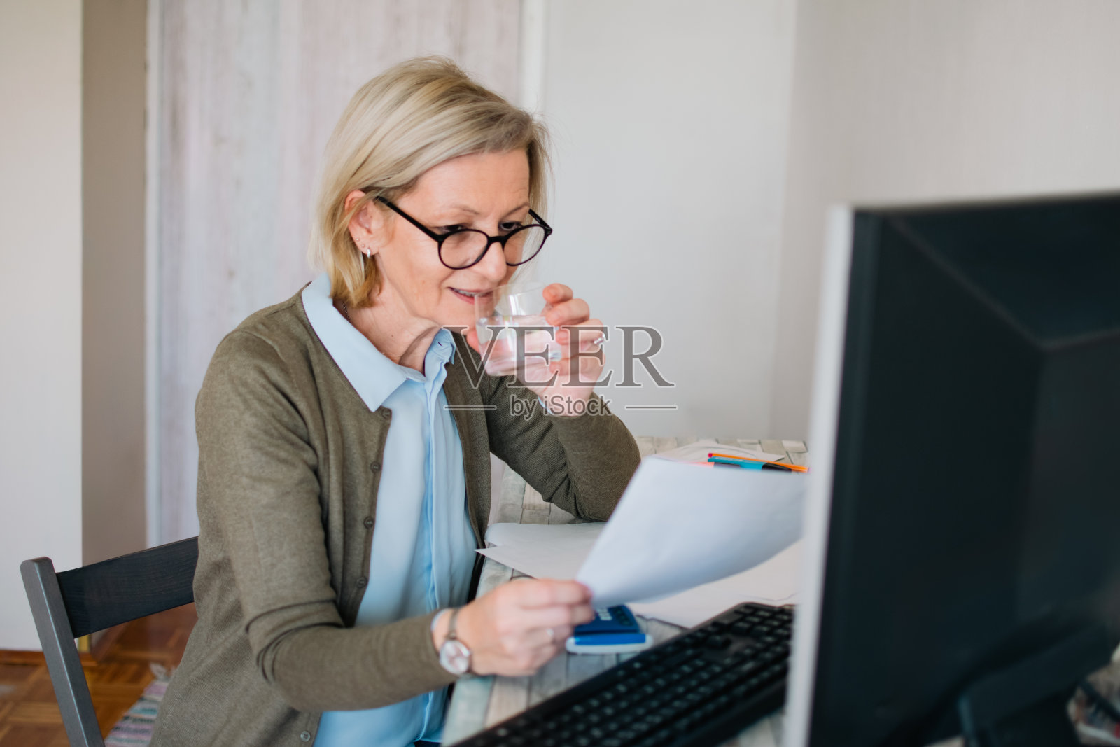 戴着眼镜的成熟金发女人在家上网工作照片摄影图片