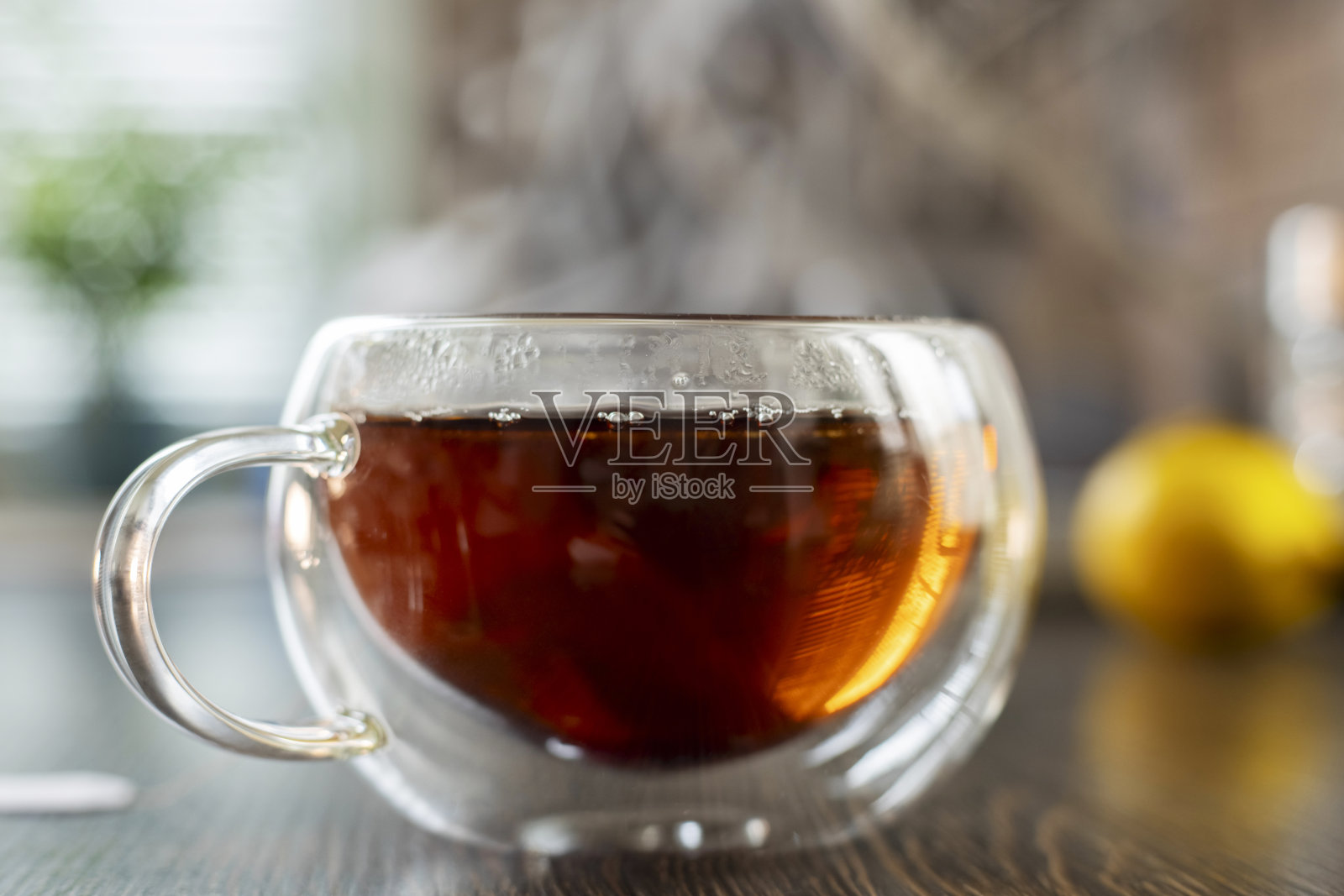 在一个透明的玻璃杯里蒸着热茶照片摄影图片