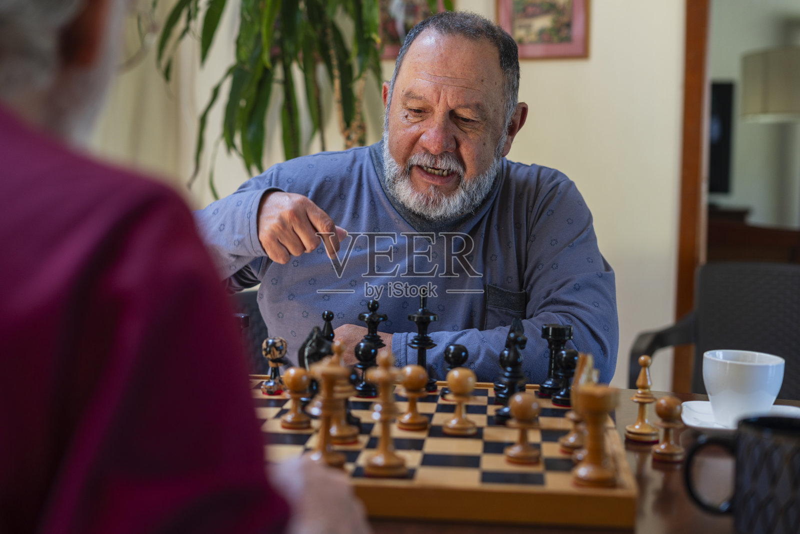 住在同一家疗养院的拉丁裔男人在一起下棋，分散注意力。照片摄影图片