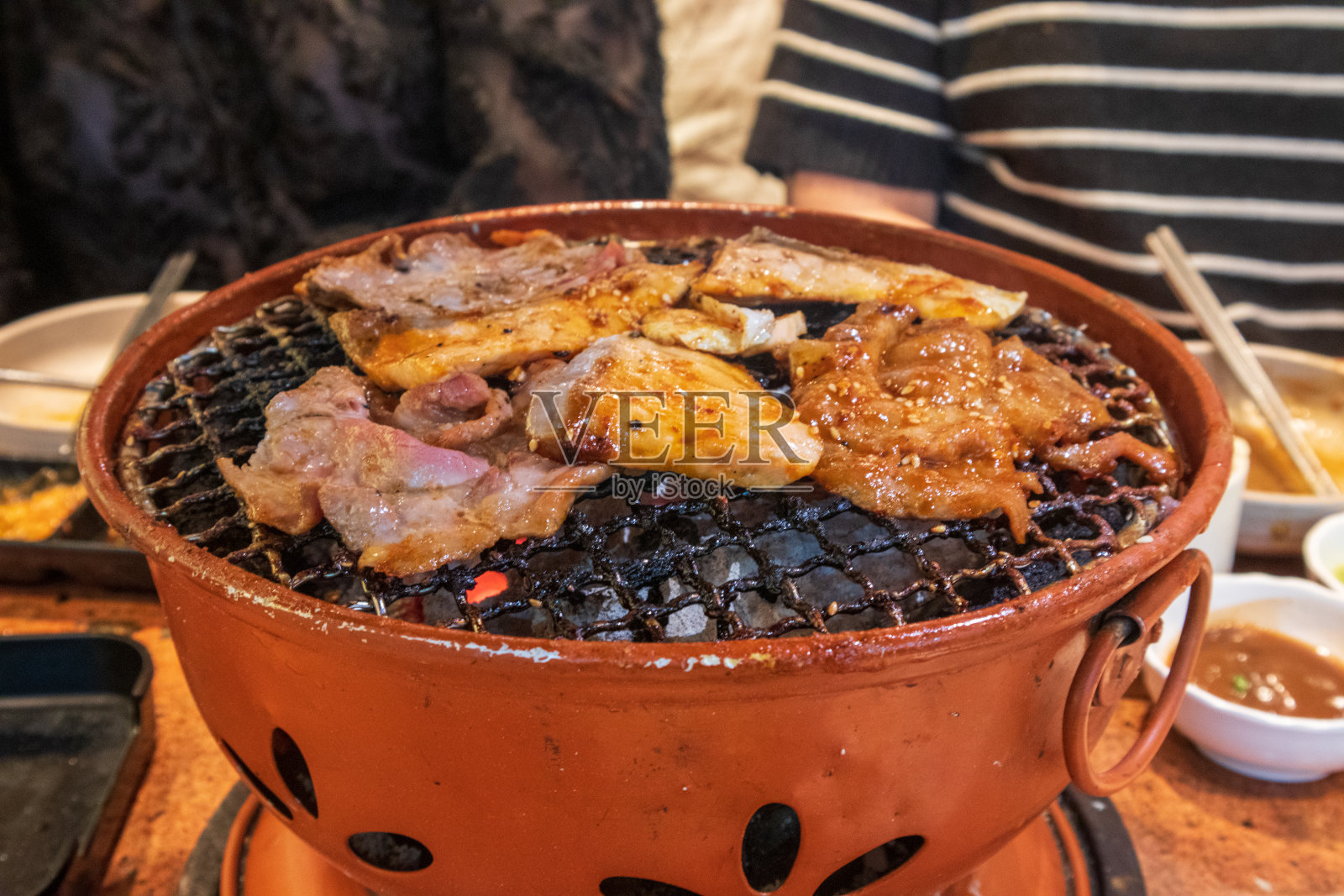 在木炭烤架上烧烤美味的猪肉和鲑鱼。照片摄影图片