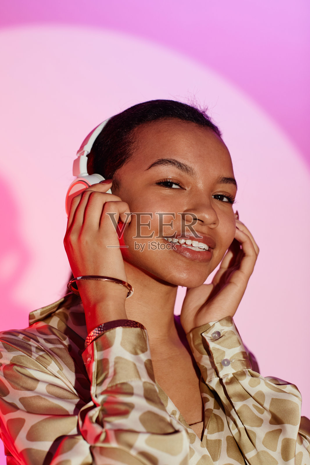 戴着耳机看着相机的快乐女孩照片摄影图片