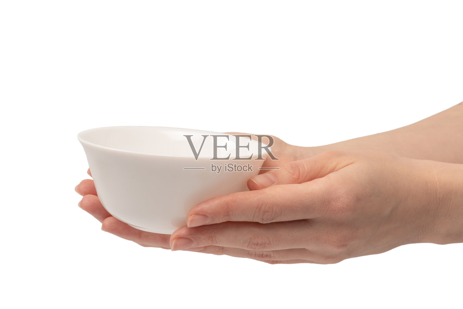 女性的手拿着一个陶瓷碗，孤立在白色的背景上。照片摄影图片
