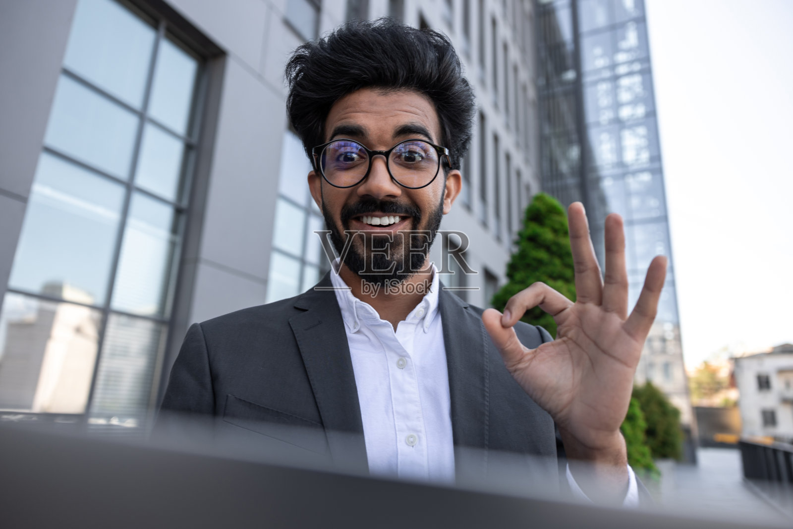 戴眼镜的年轻商人感到积极和快乐照片摄影图片