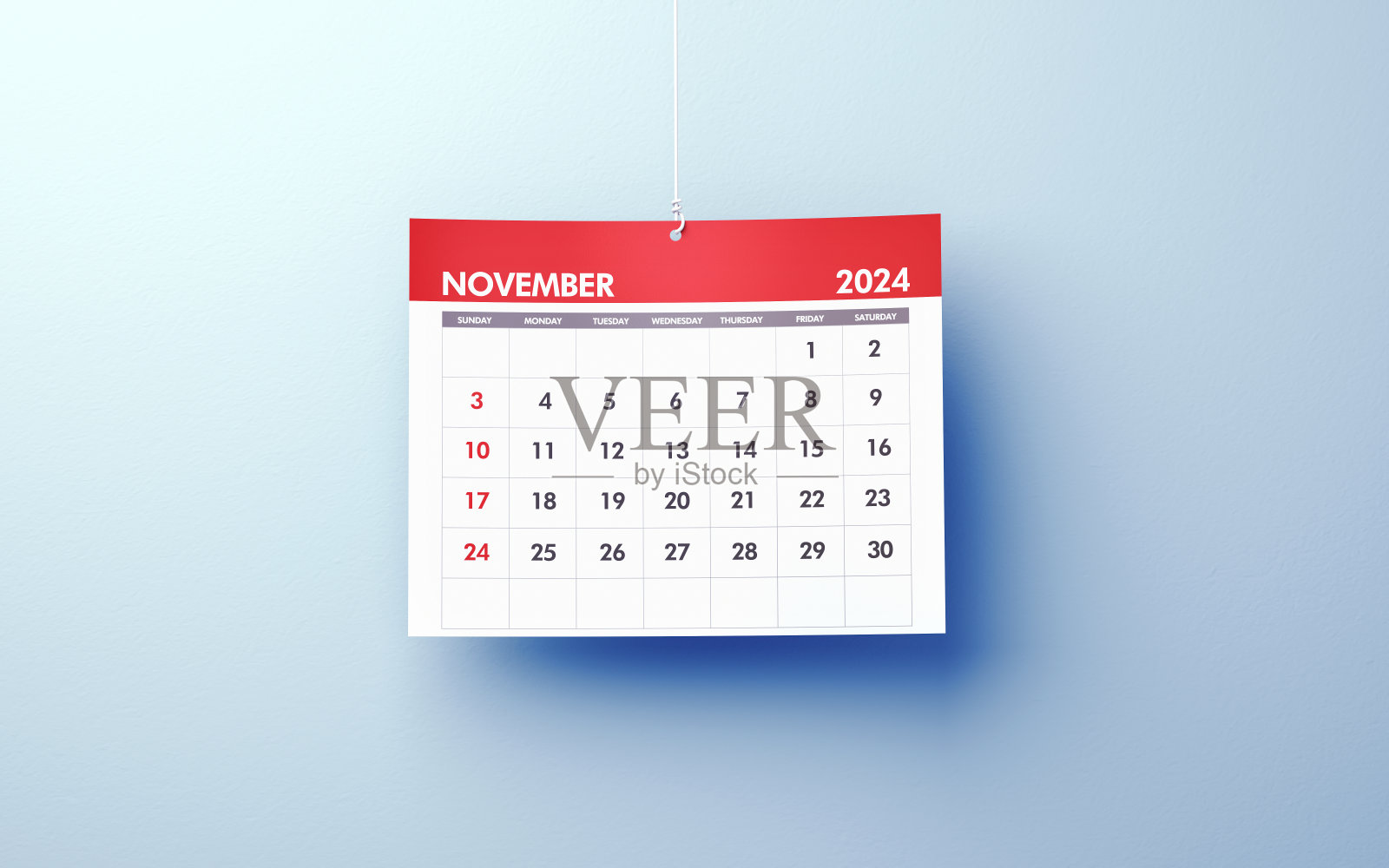 2024年11月的日历挂在蓝色背景的绳子上照片摄影图片