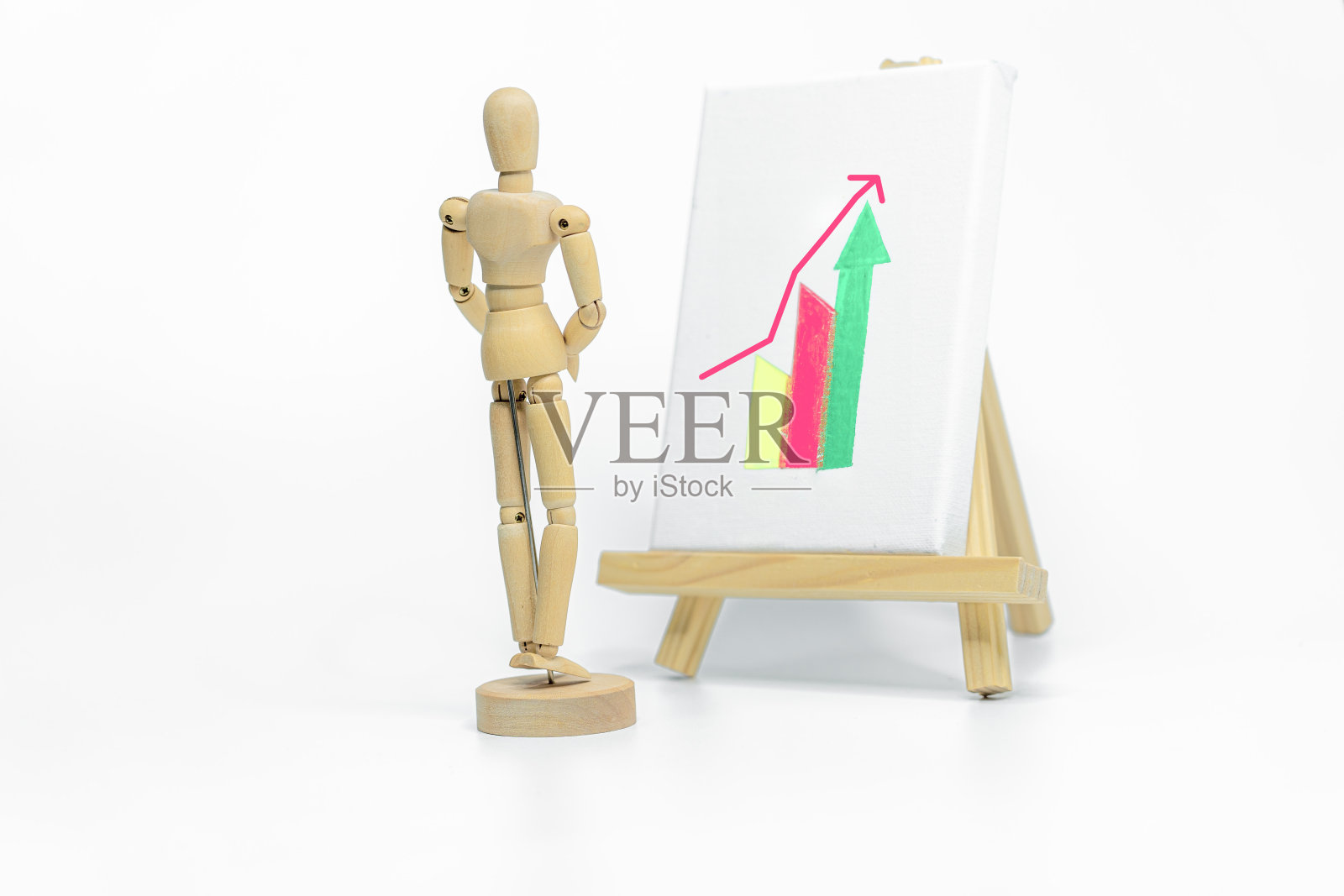人体模型在画架上绘制图表;孤立在白色背景上;商业或金融概念照片摄影图片