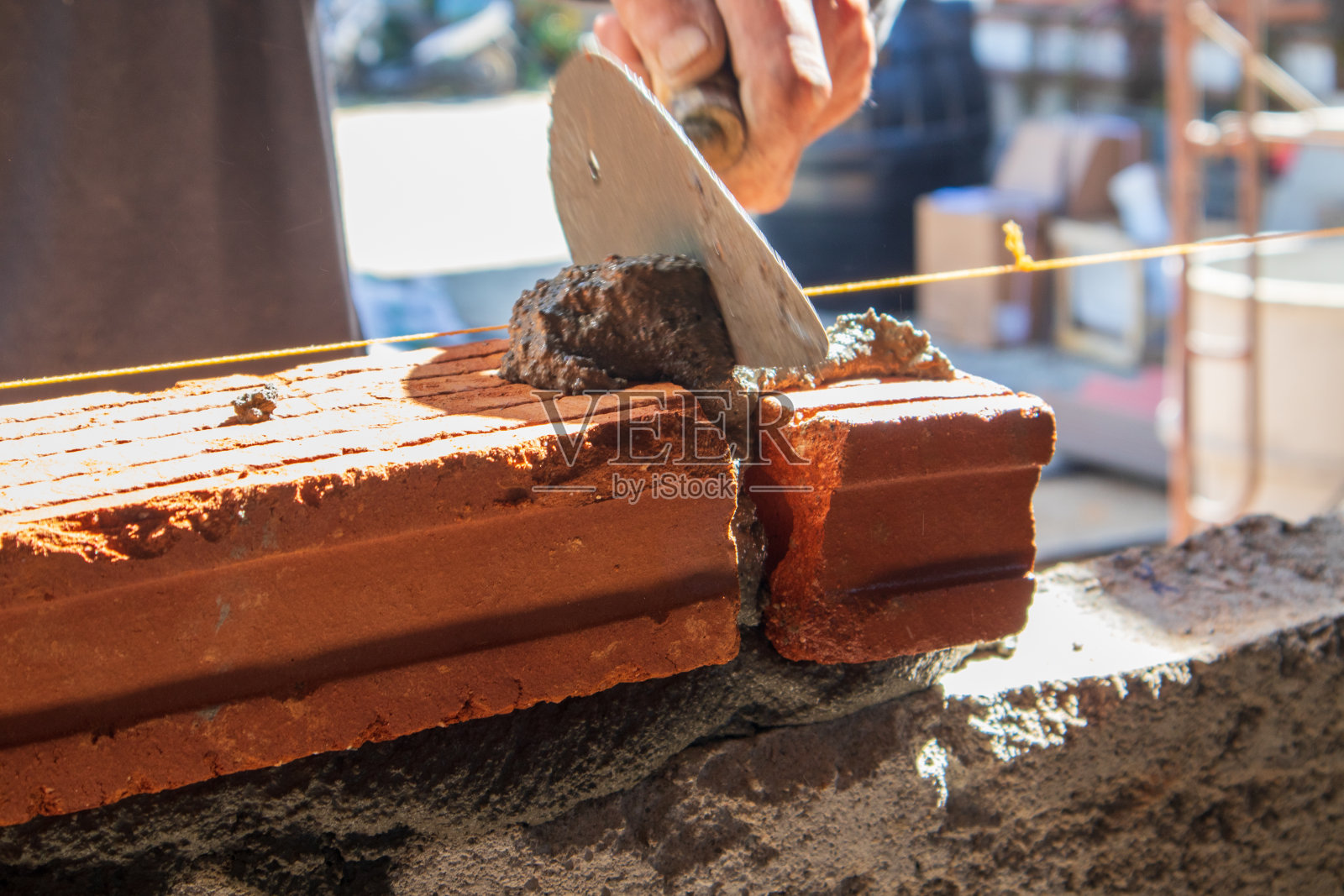 在建筑房屋施工中，抹灰后工人的手在砌砖照片摄影图片