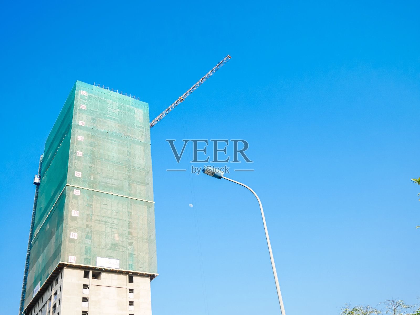 在越南河内的城市住房中，高层公寓正在建设绿色安全网，防止建筑材料或工作人员掉落照片摄影图片