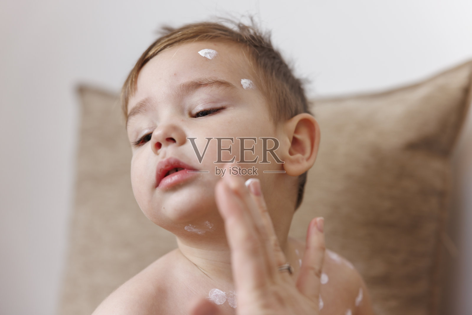 母亲在孩子的水痘上涂抹药膏照片摄影图片