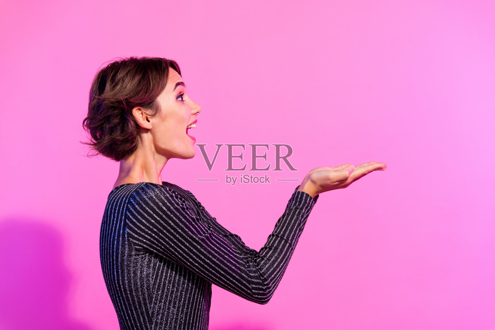 照片中闪亮的印象深刻的女士穿着迷人的服装，抱着手臂空的空间孤立的生动的粉红色背景照片摄影图片