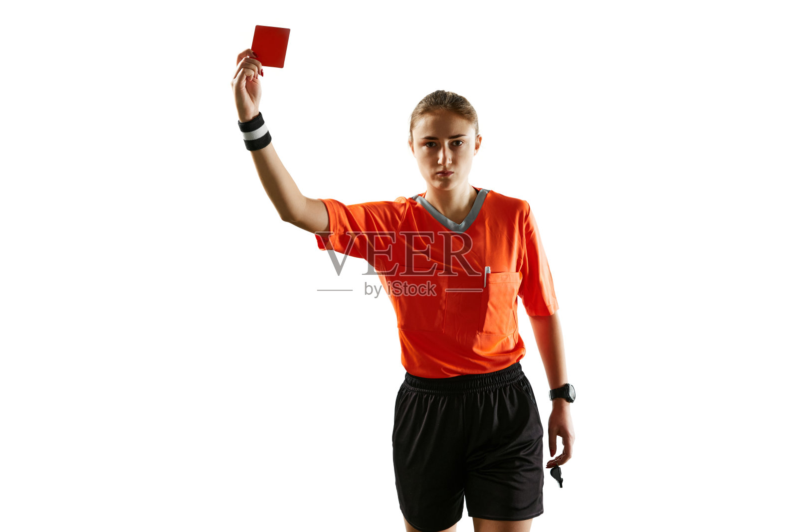 严肃的年轻女子，穿着制服的足球裁判，在白色的摄影棚背景下出示红牌作为解雇标志照片摄影图片