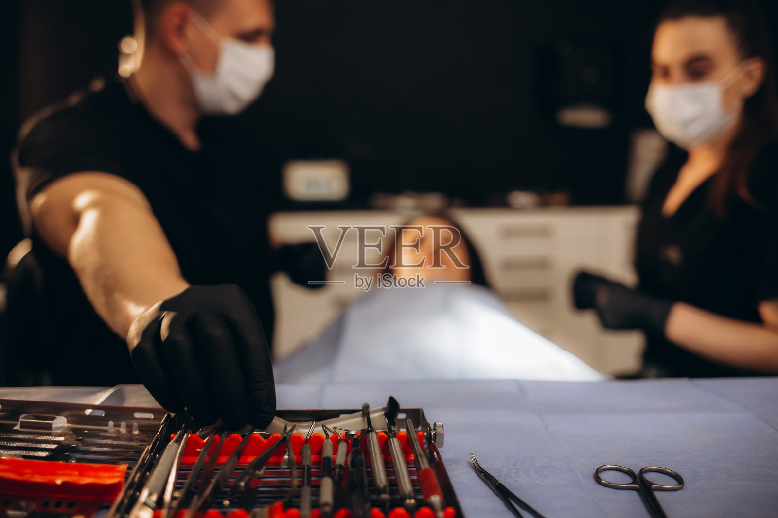 隆鼻手术时，外科医生戴着手套拿着器械。隆鼻手术时，医生戴着手套拿着医疗器械照片摄影图片