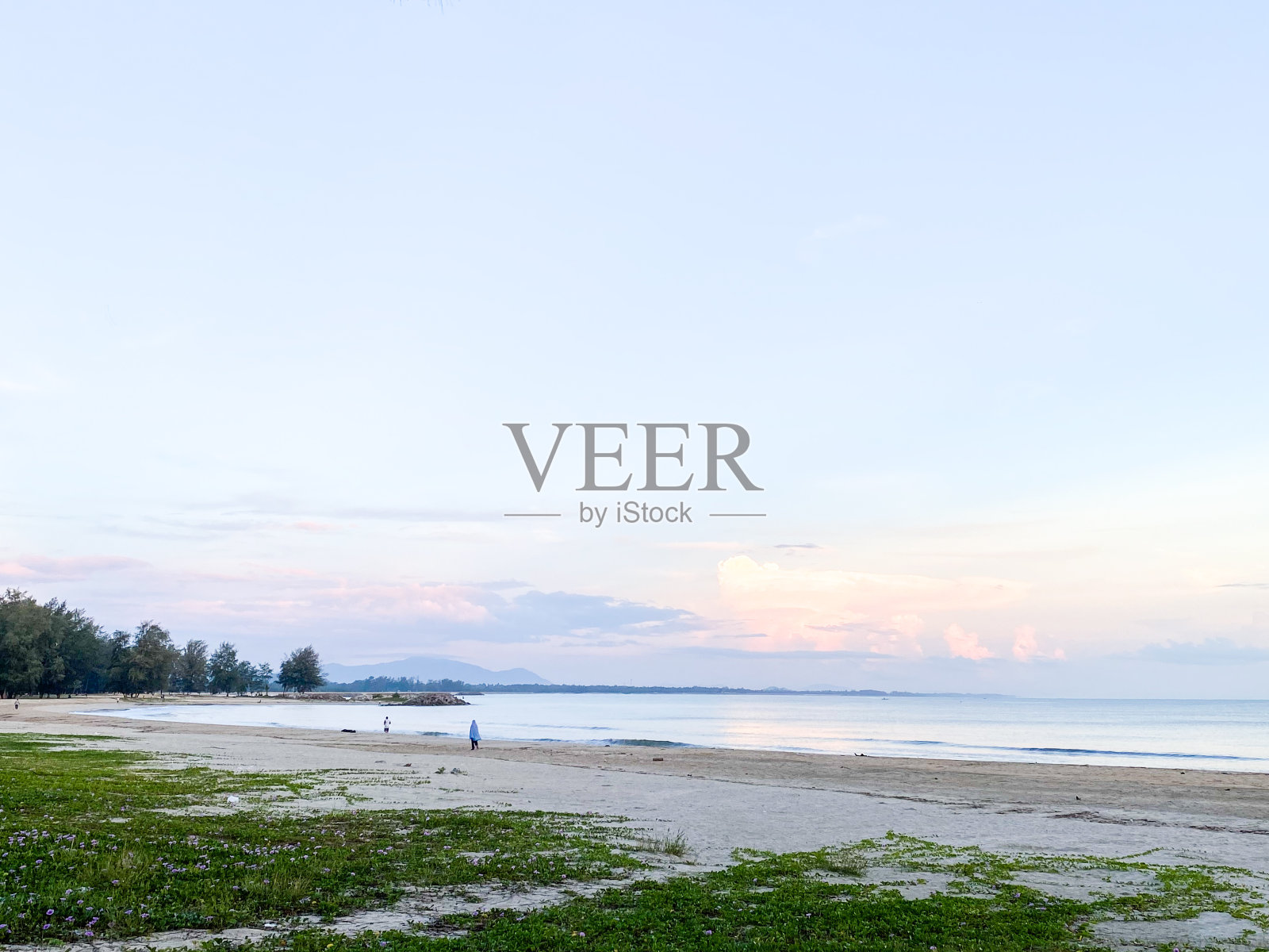 海滩的沙滩沿着海岸延伸，为寻求和平逃离的海滩爱好者提供了一个宁静祥和的环境。照片摄影图片