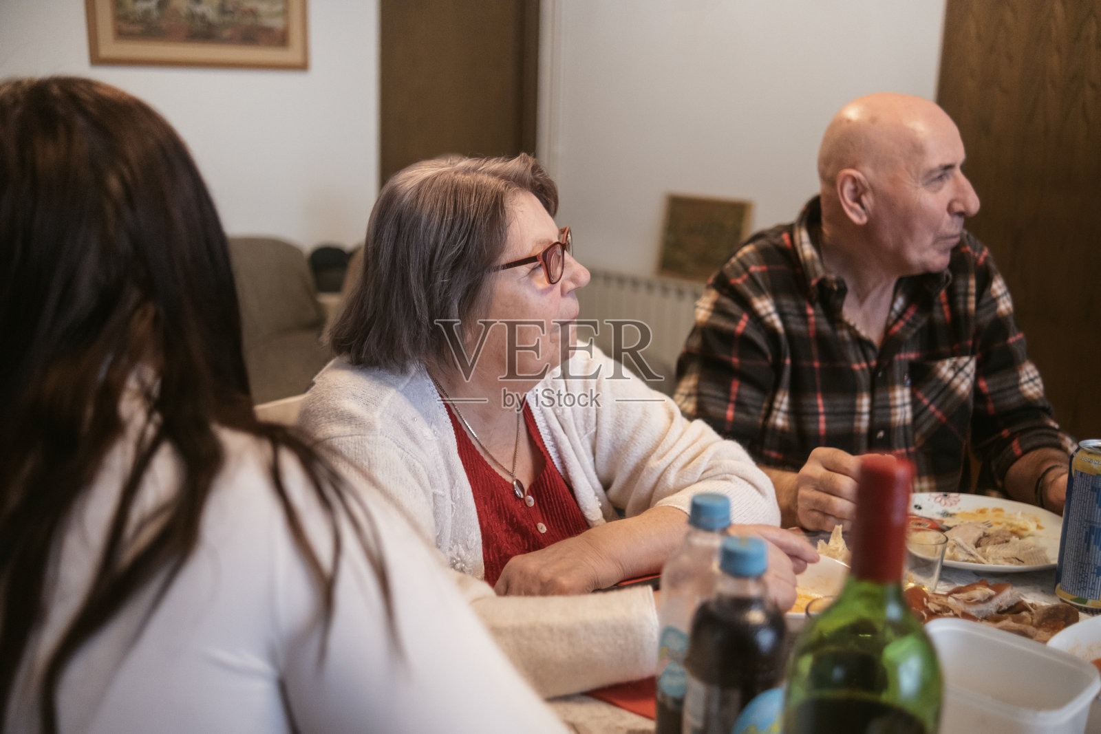 孙女一边吃饭一边和爷爷奶奶看电视照片摄影图片
