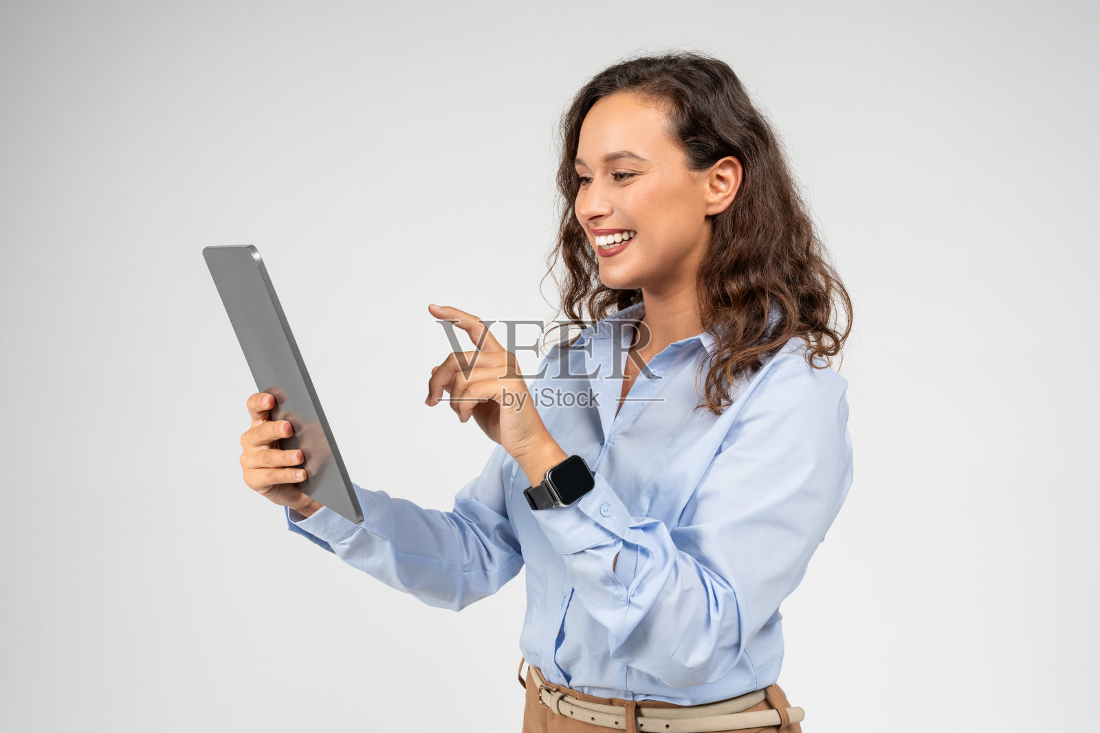 很高兴受到鼓舞的白人年轻女商人使用平板电脑，在屏幕上输入手指照片摄影图片