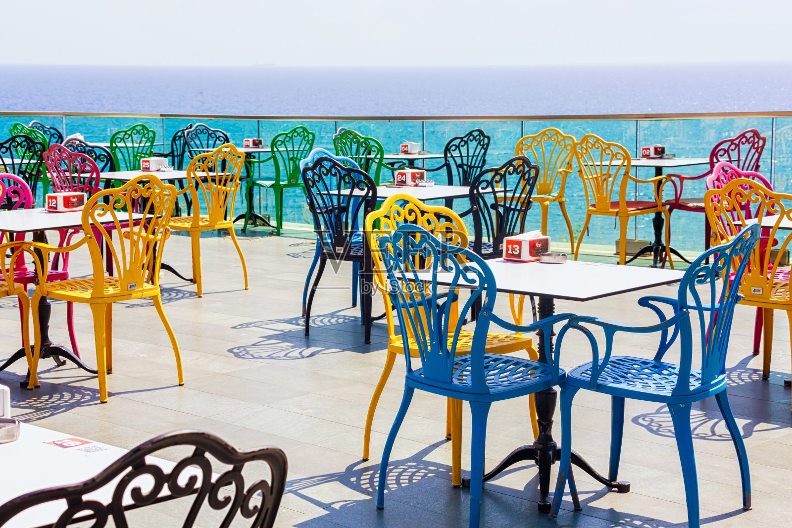 餐厅里的彩色椅子可以看到大海和老城区。咖啡馆、地中海和山脉的美丽顶景。2023年7月28日。安塔利亚，土耳其(土耳其语)照片摄影图片