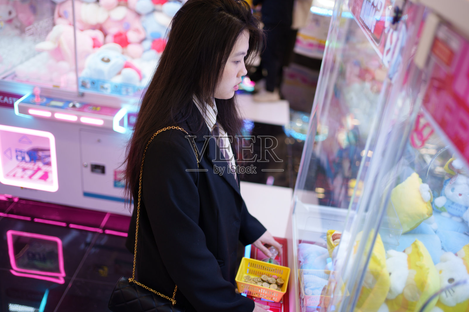 年轻女子在玩娃娃机照片摄影图片