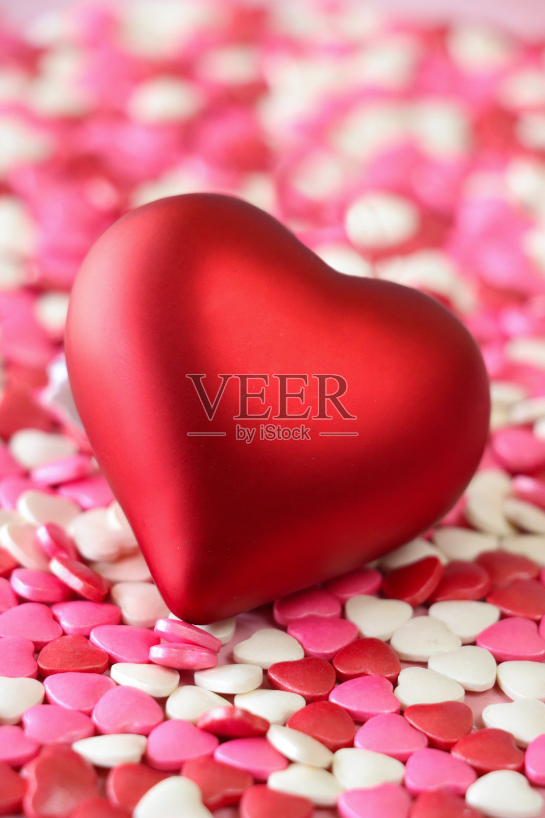 金属的全画幅图像，红色模型心堆在红色，粉红色和白色的糖果心，情人节装饰，斑纹粉红色的背景，抬高的观点，重点在前景，情人节和浪漫的概念照片摄影图片