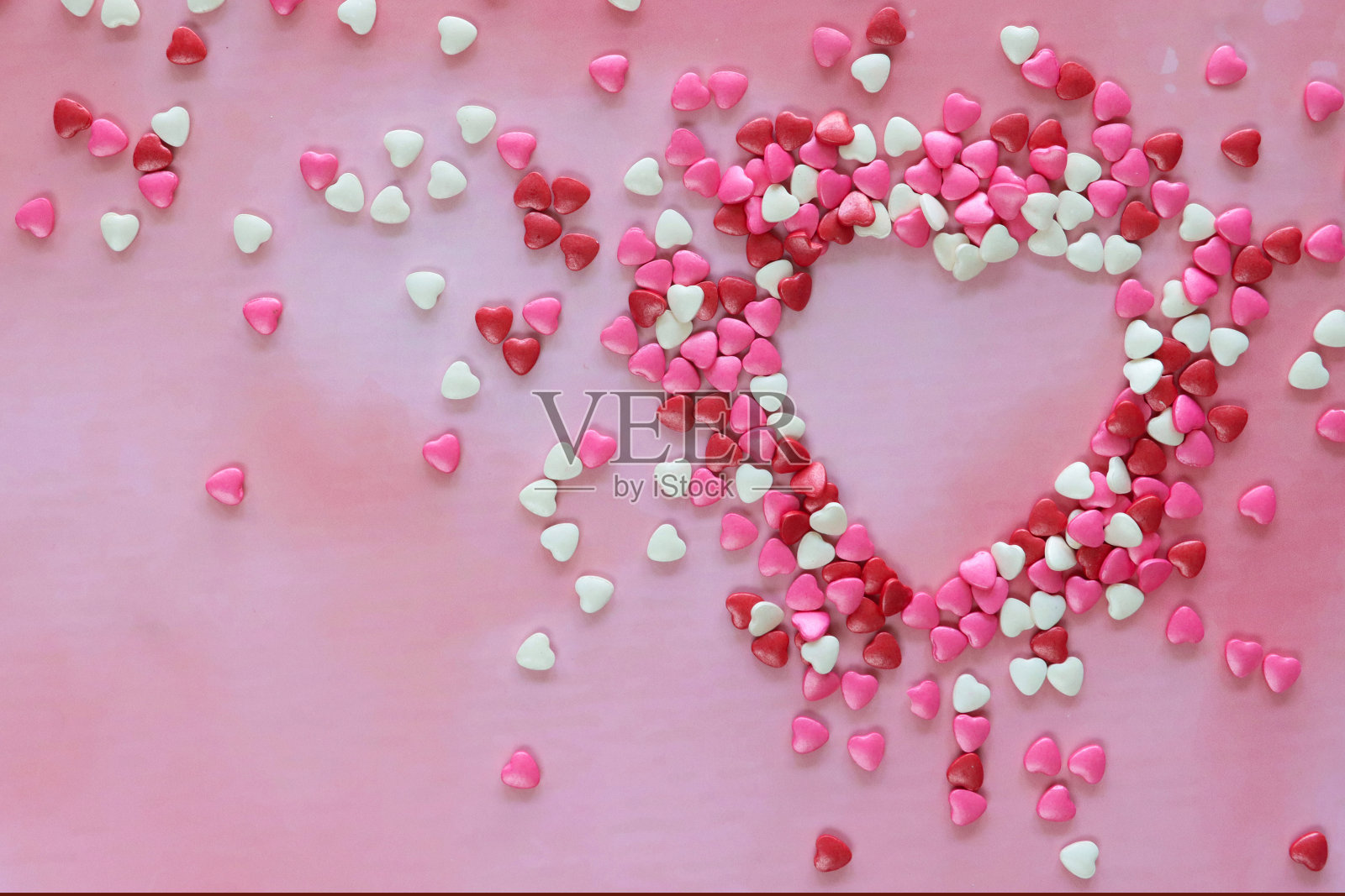 形象心形由红色、粉色和白色心形糖果打造，情人节装饰，斑纹粉色背景，抬高视野，情人节和浪漫的概念，复制空间照片摄影图片
