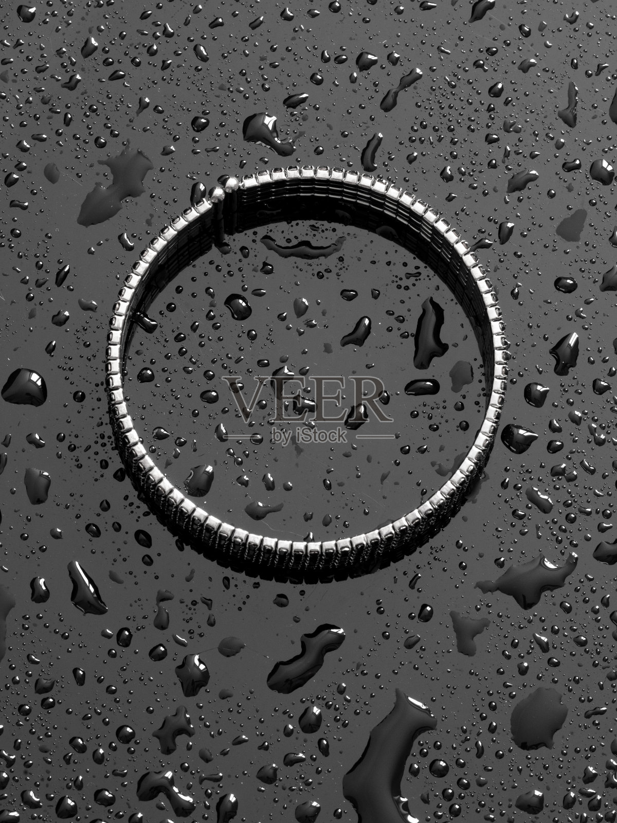 黑色背景上的水滴银色手镯照片摄影图片