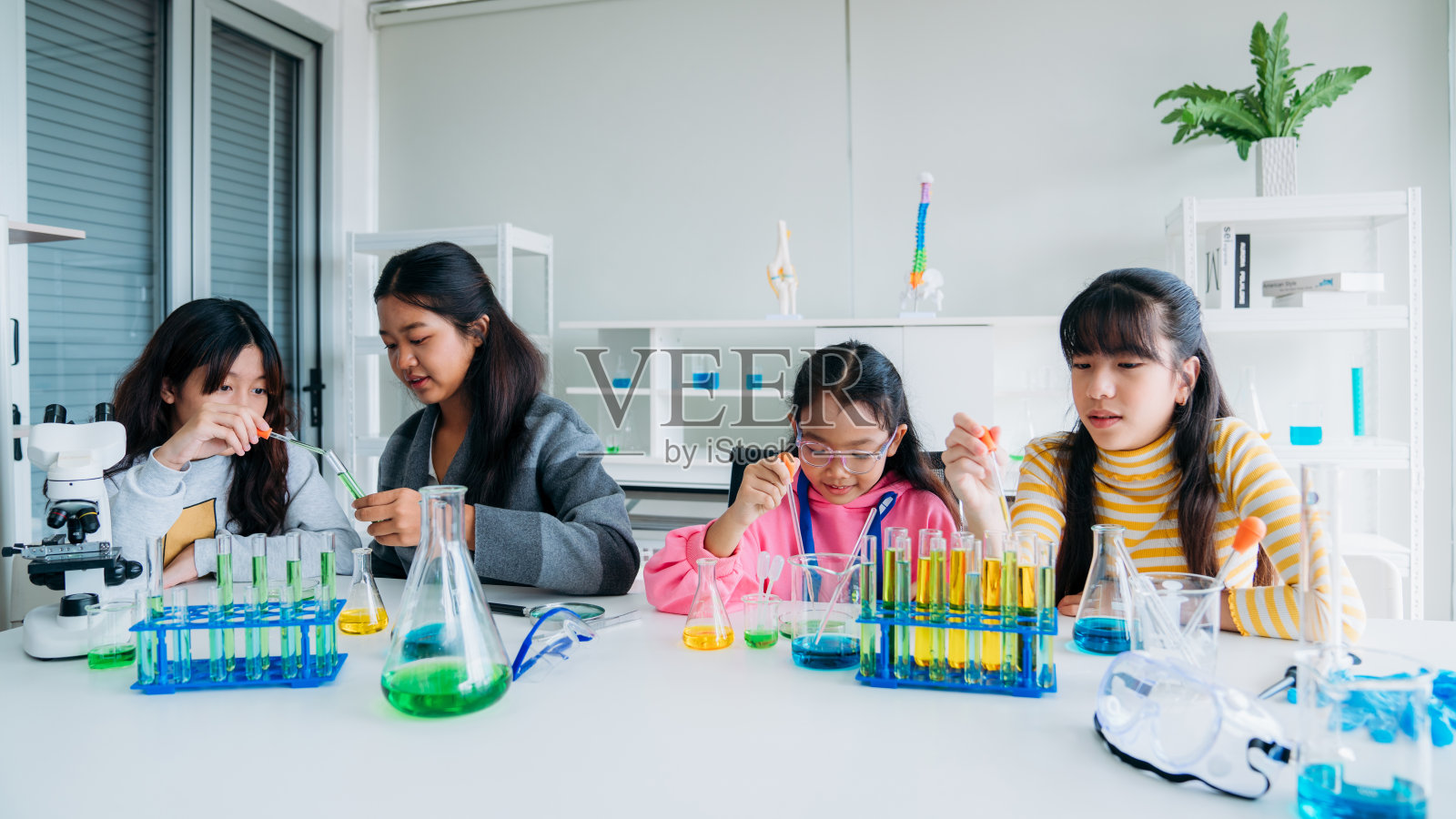 小学班的孩子们从事动手科学实验。学生通过互动和吸引人的实验发现科学的奇迹。照片摄影图片