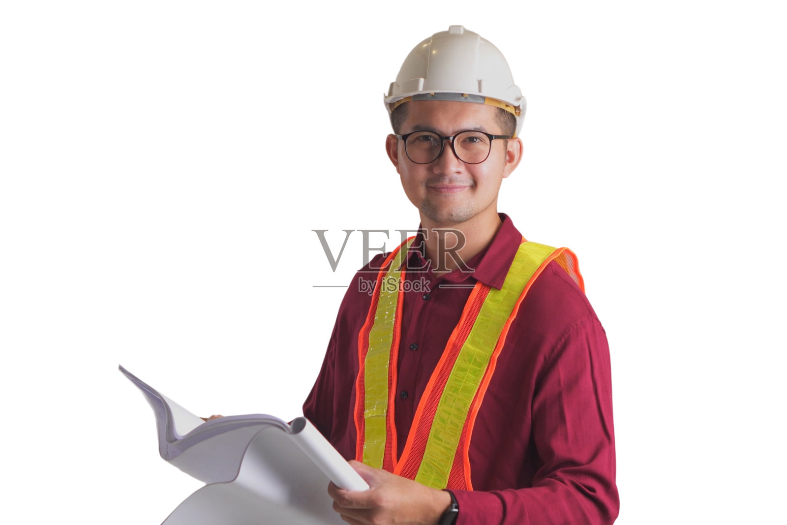年轻的亚洲微笑着英俊的工程师，戴着白色头盔，拿着蓝图，在白色的背景上看着相机。照片摄影图片