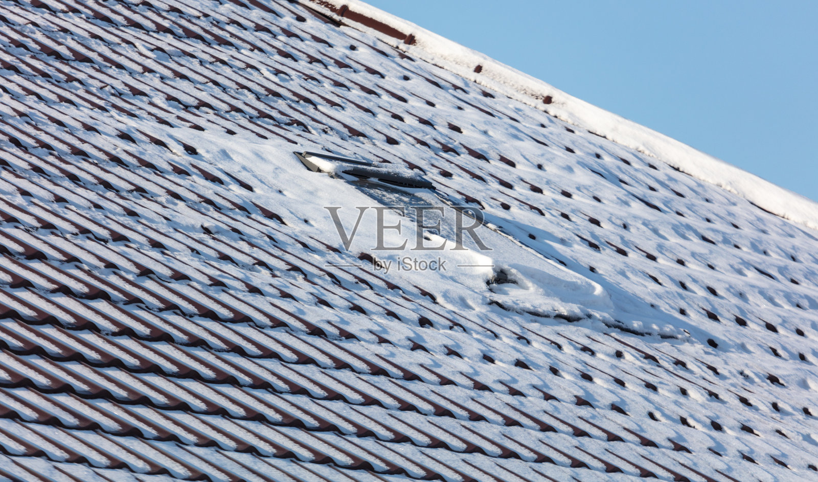 白雪覆盖的屋顶映衬着蓝天照片摄影图片