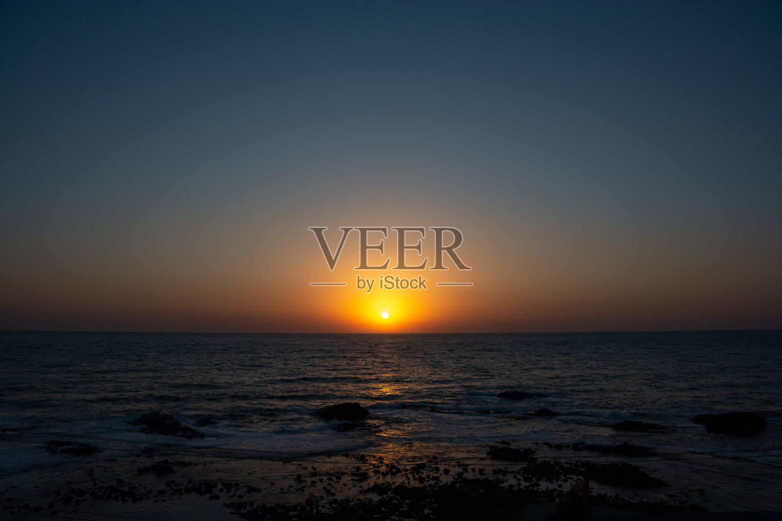 日落在平静的海面上照片摄影图片