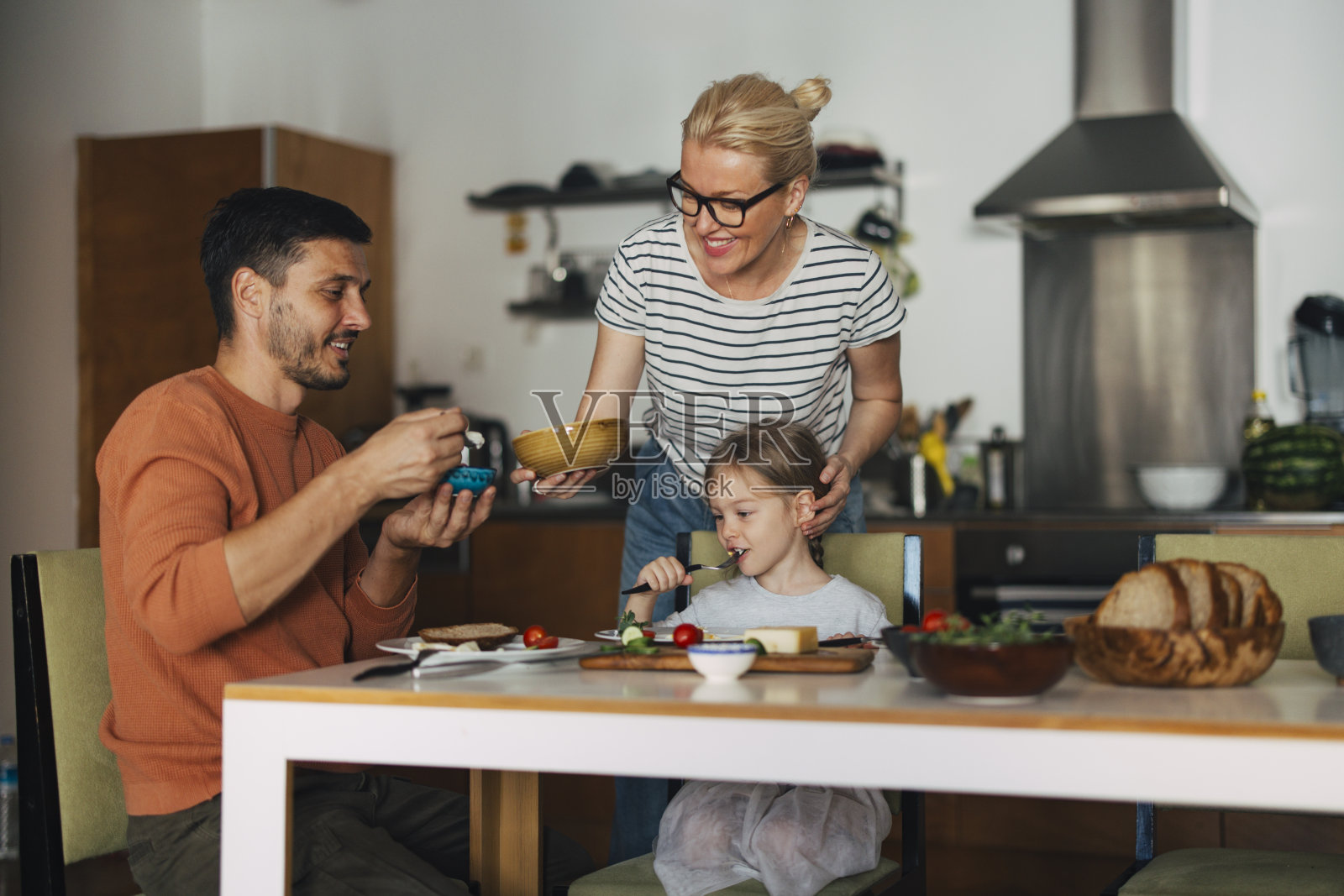 幸福的一家三口在家吃早餐照片摄影图片