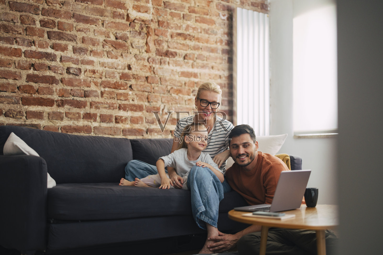 在家里休息的时候，在笔记本电脑上看一些快乐的家庭照片摄影图片