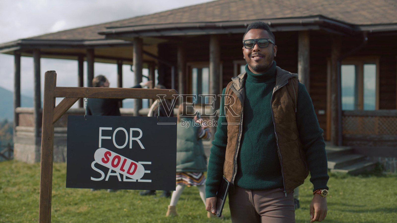 非裔美国房地产经纪人站在待售标牌旁，看着镜头照片摄影图片