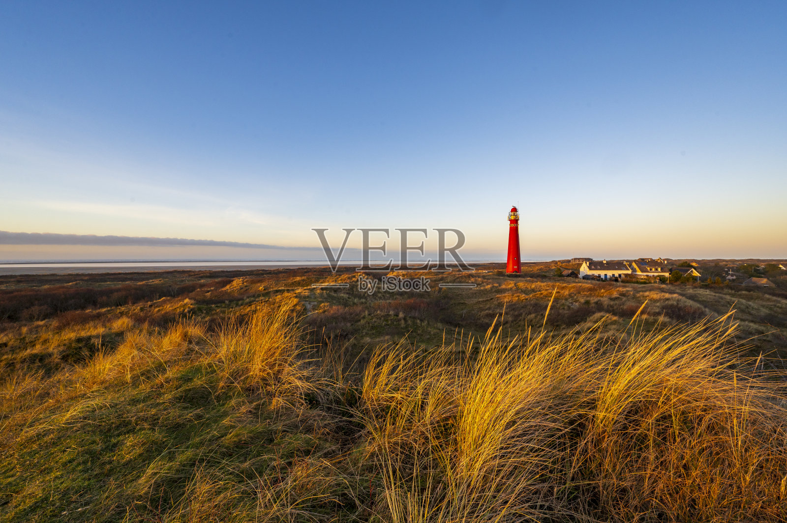 日落时分，Schiermonnikoog的沙丘全景与灯塔照片摄影图片