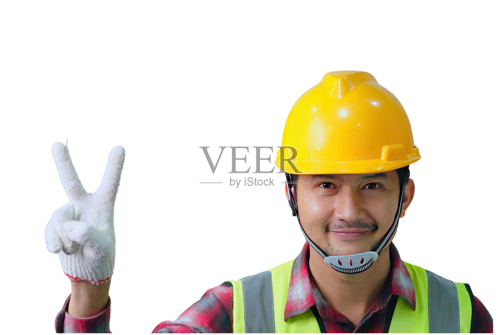 工人穿着安全服，戴着黄色头盔，微笑着举起两个大拇指，孤立在白色背景上。照片摄影图片