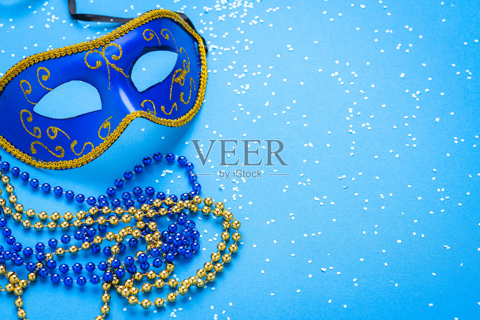 绿色背景上的蓝色狂欢节面具。副本的空间。照片摄影图片