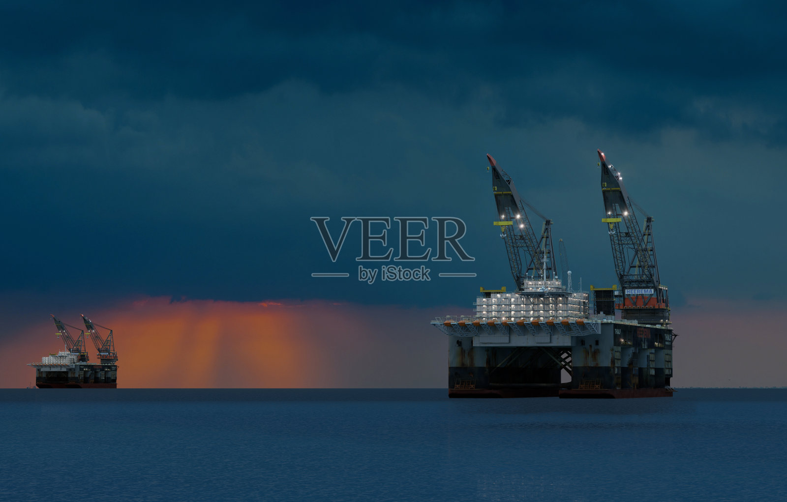 日落时海上的石油钻井平台照片摄影图片