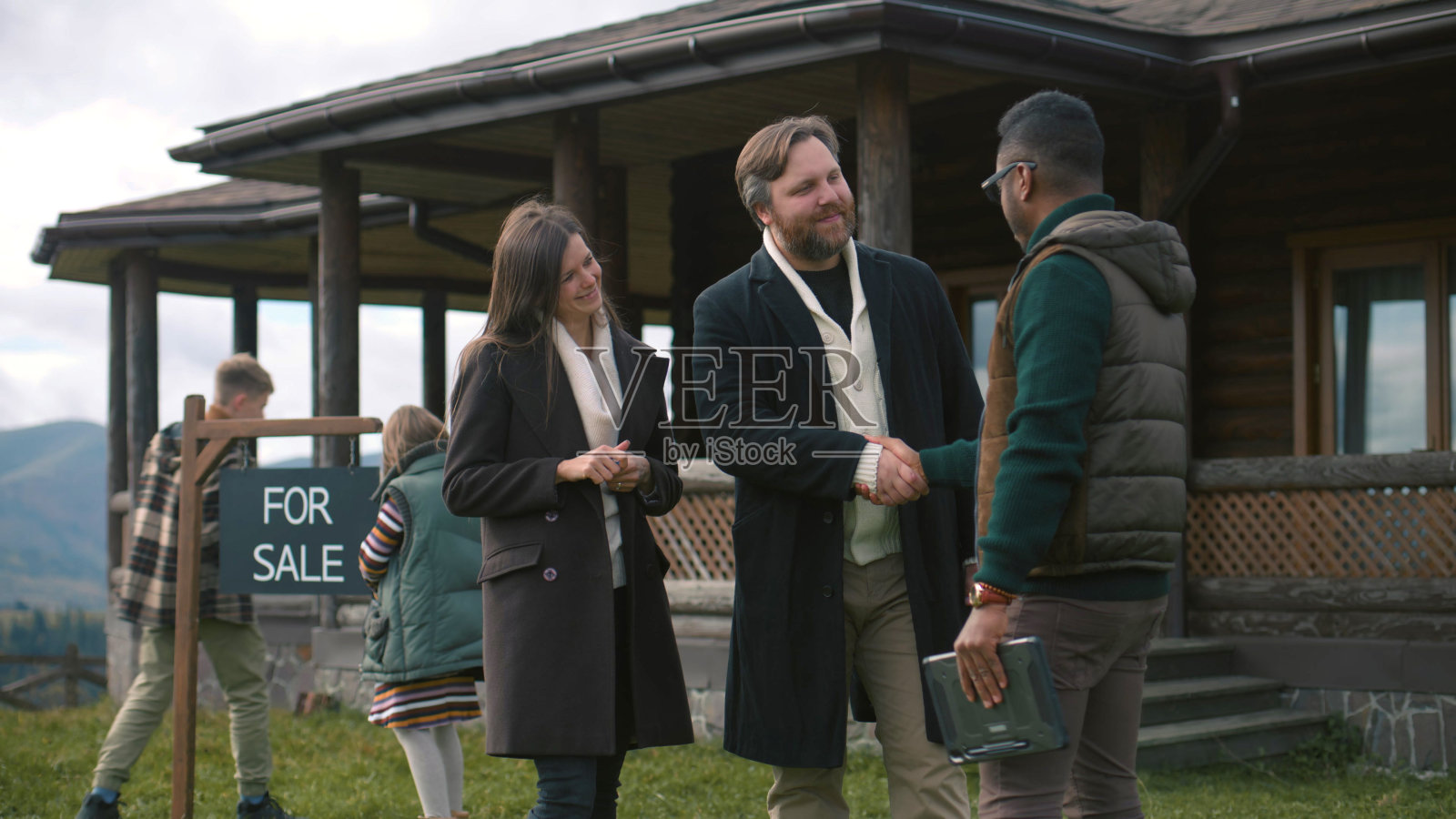 非裔美国房地产经纪人为幸福的白人夫妇提供钥匙照片摄影图片