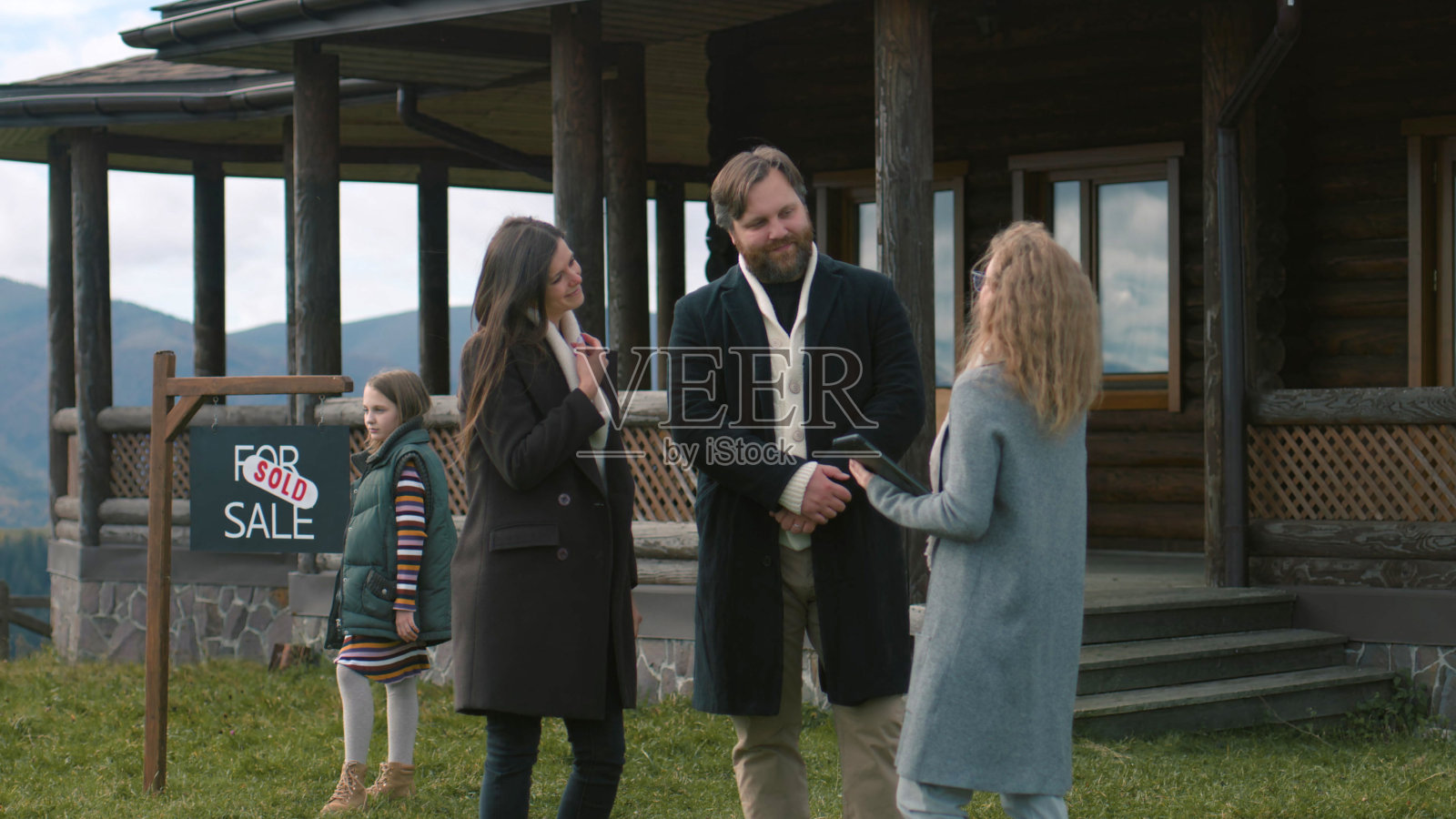 女房地产经纪人给有孩子的年轻家庭钥匙照片摄影图片