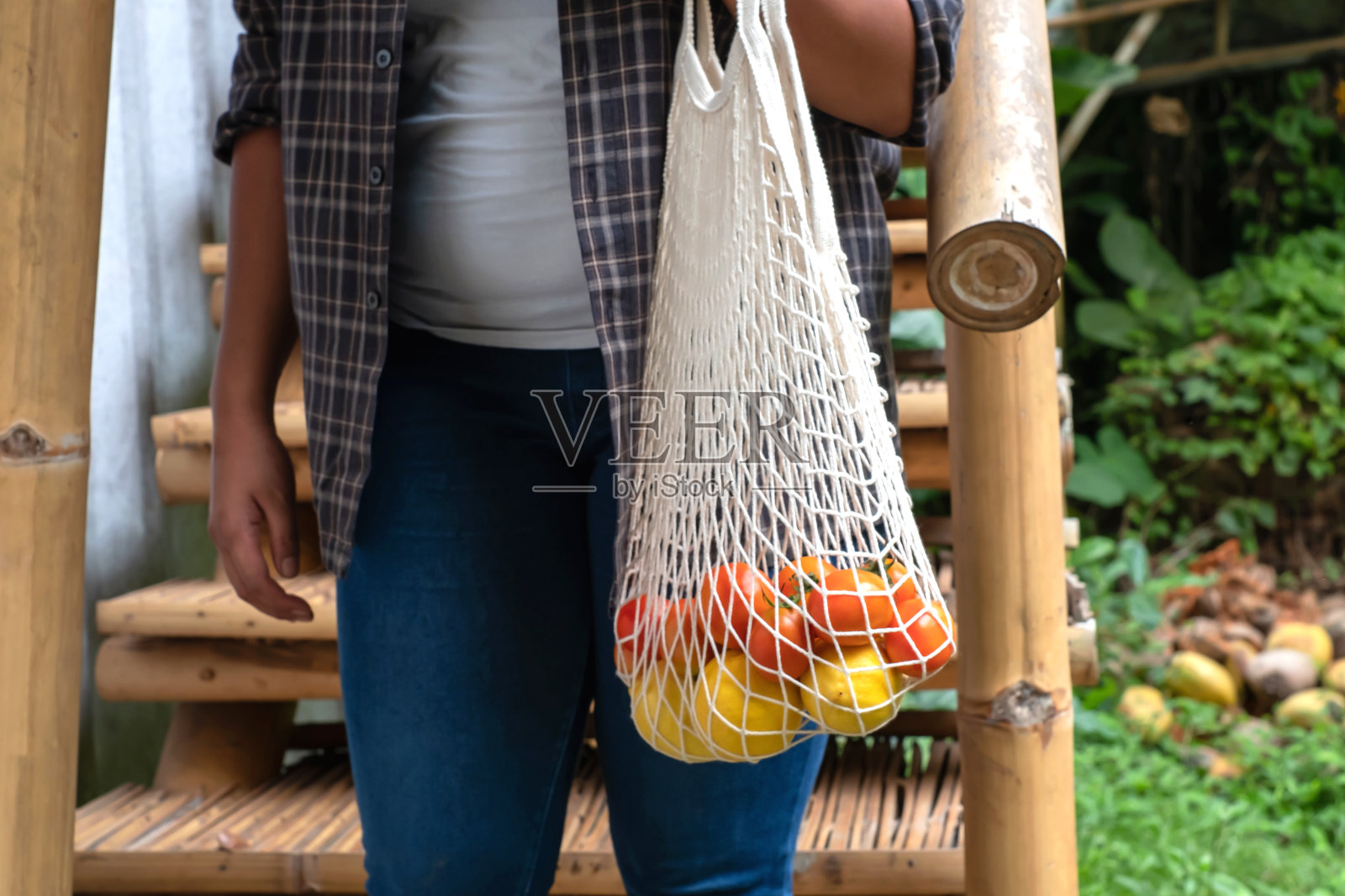 不可识别的妇女购物杂货使用可重复使用的棉网购物袋照片摄影图片