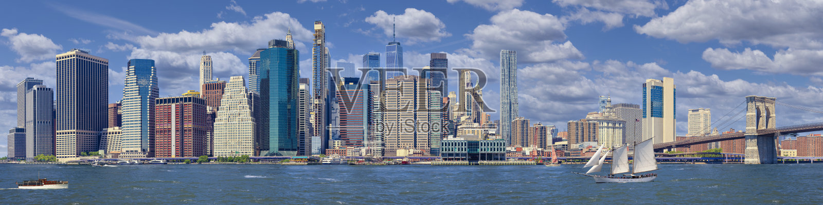 纽约天际线，曼哈顿金融区、世界贸易中心、布鲁克林大桥、东河和清晨蓝天的摩天大楼。照片摄影图片