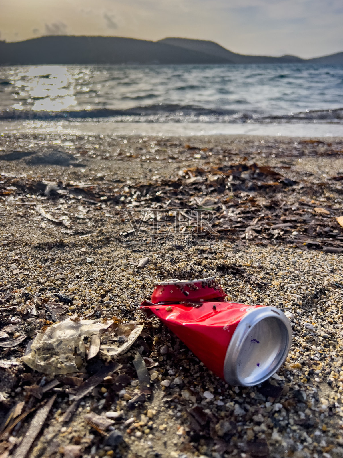 海边沙滩上丢弃的锡罐垃圾。照片摄影图片