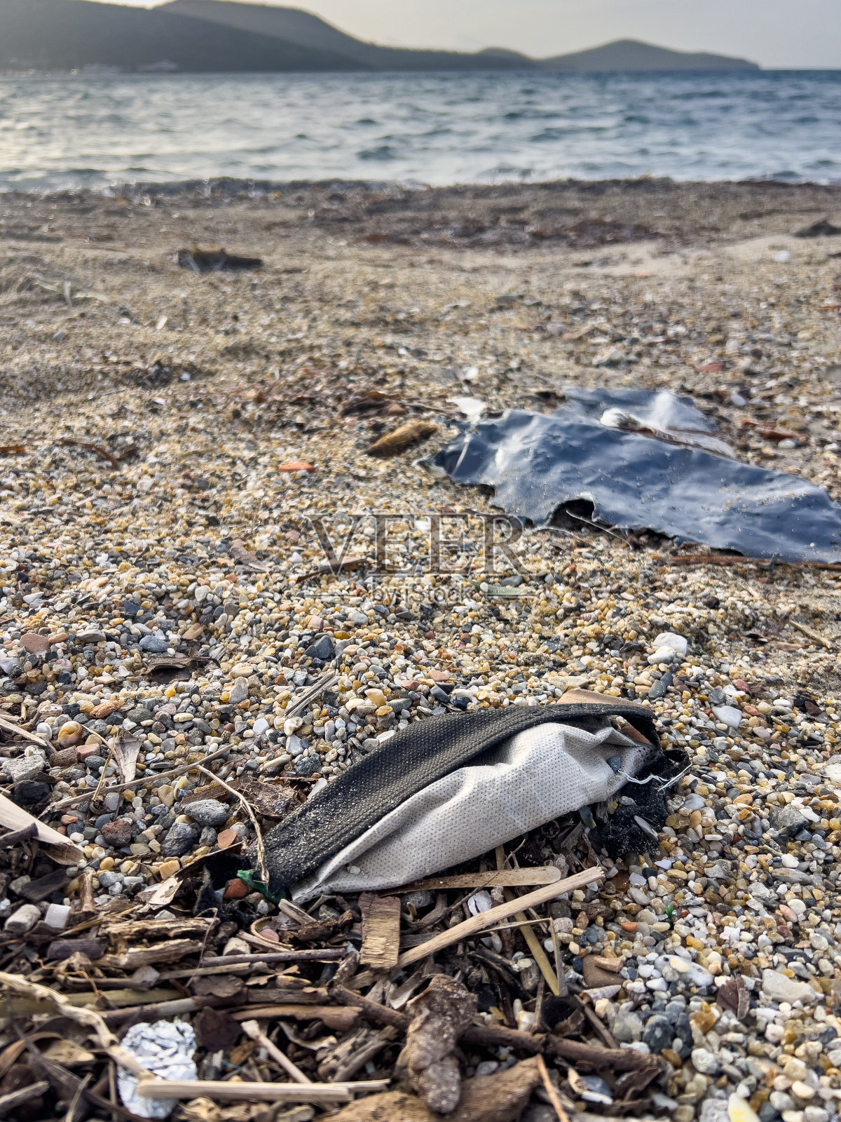 海边沙滩上被丢弃的各种垃圾。照片摄影图片