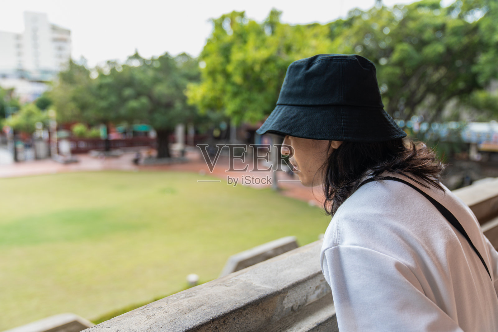 一个亚洲人在窗边看照片摄影图片