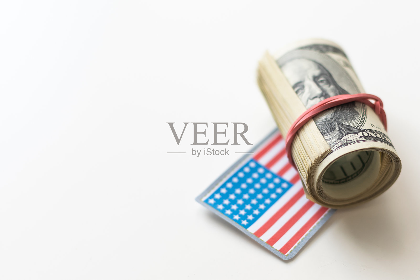 美钞堆上的美国国旗。照片摄影图片